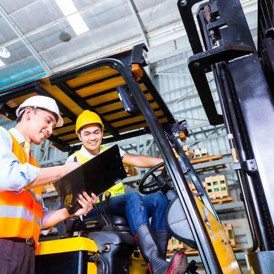 fork lift truck driver discussing checklist with foreman in warehouse